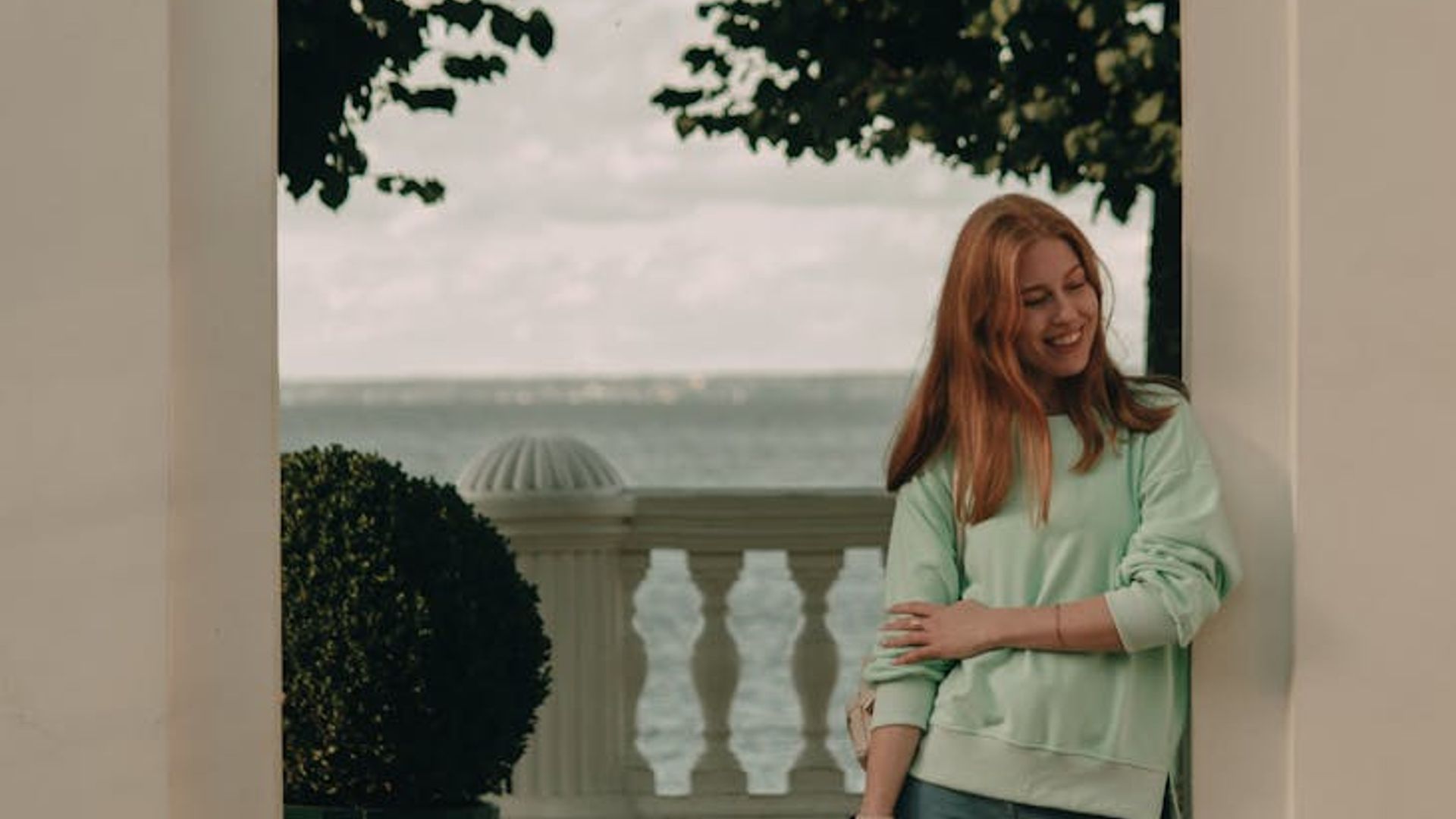 Person looking into the distance in a green park landscape.